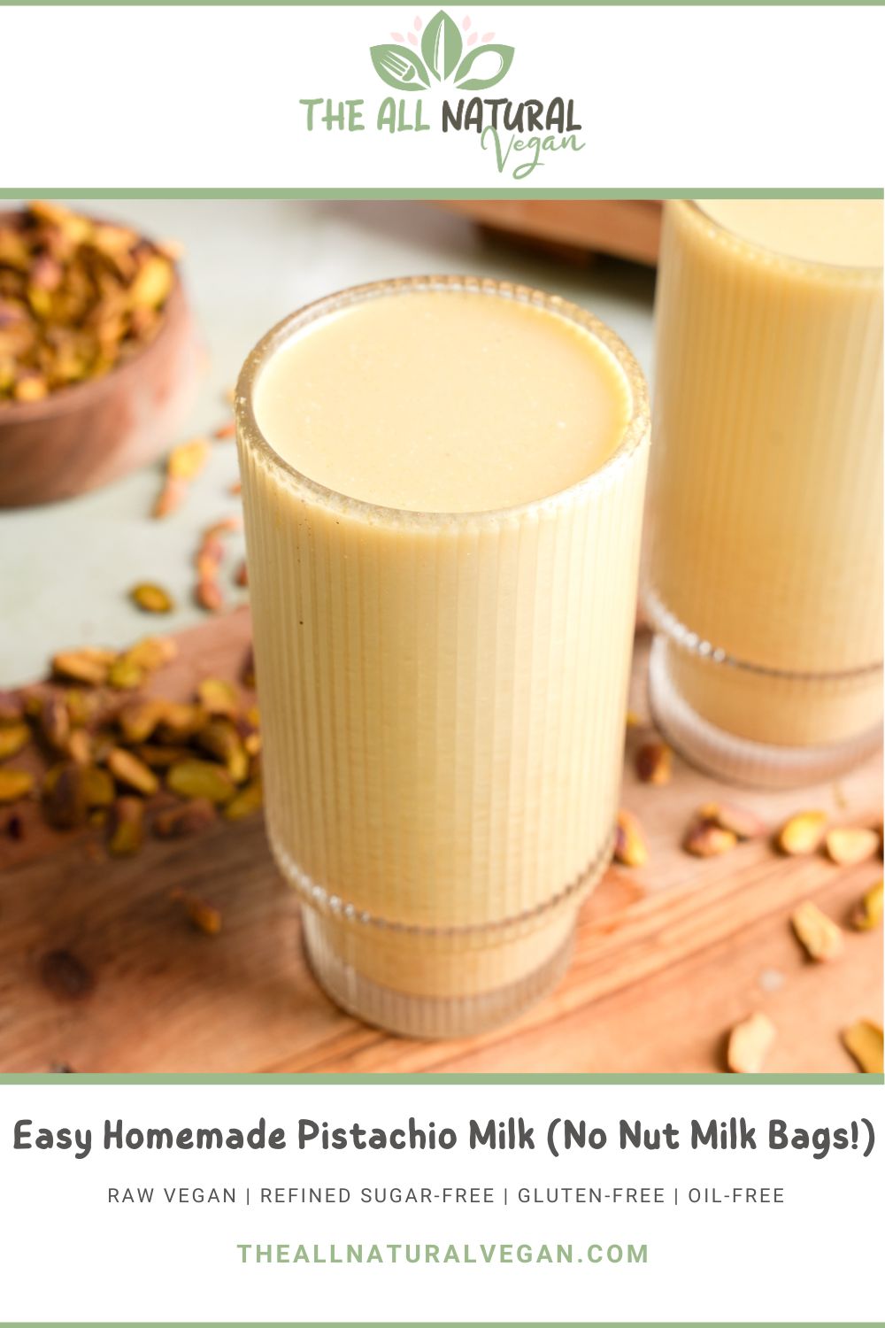 Glass of homemade pistachio milk on a wooden cutting board, surrounded by scattered shelled pistachios, with a rustic bowl in the background, highlighting a smooth, creamy, pastel green drink made without nut milk bags.